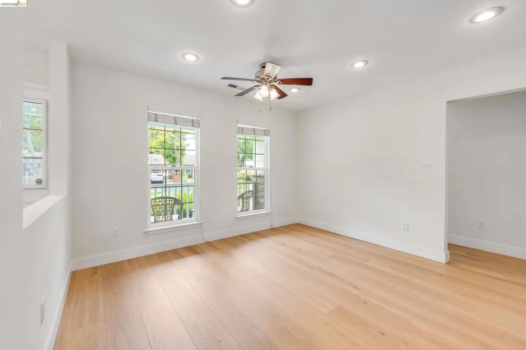 Bright interior space featuring light wood-finish flooring, recessed lighting, and a ceiling fan with integrated light