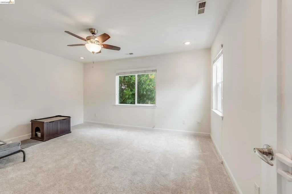 Spacious room featuring neutral carpeting and white walls