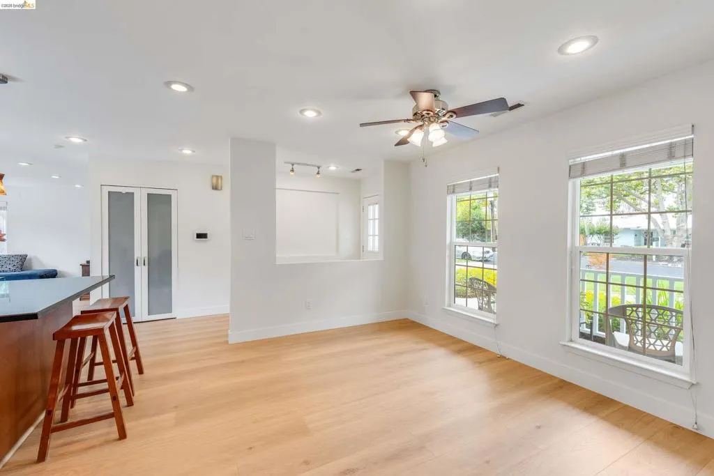 Open-concept living space with light wood-finish flooring, recessed lighting, and a ceiling fan