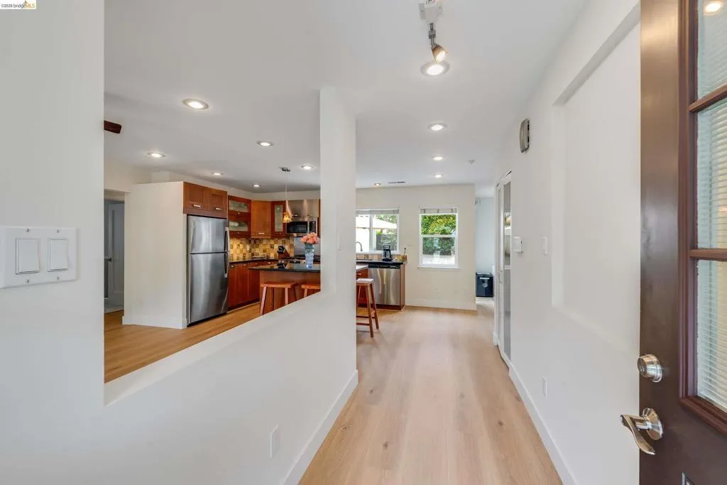 Entryway featuring light wood-finish flooring, recessed lighting, and a partial wall opening to the kitchen