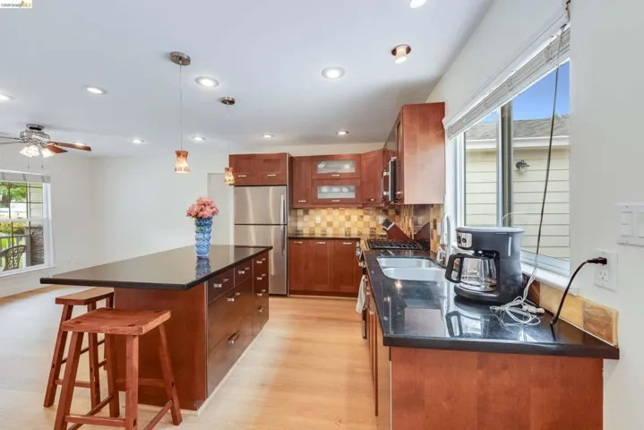 Kitchen featuring wood cabinetry, stainless steel appliances, and dark countertops