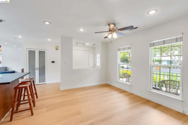 Open-concept living space with light wood-finish flooring, recessed lighting, and a ceiling fan
