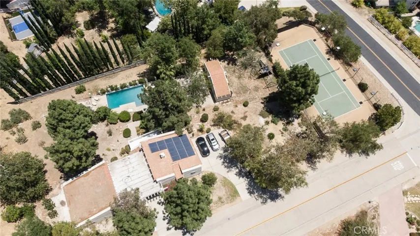 Ariel view of the 1+ acre property showing the house, pool, guest house, and tennis court.