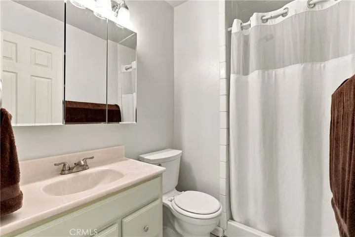 The ensuite bathroom has a large mirrored medicine cabinet and tile surround shower.