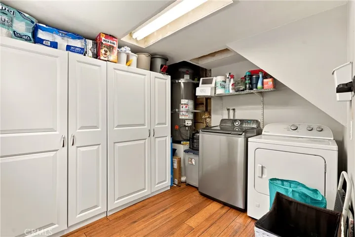 The laundry room is past the stairs and has plenty of room for additional storage. Washer and dryer stay!