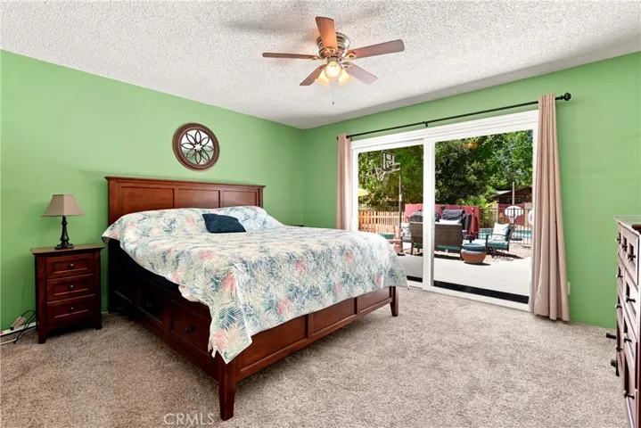 At the end of the hallway is the primary suite. It boasts a large sliding glass door that leads to the backyard.