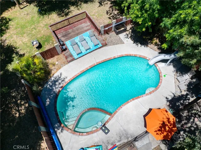 Hot tub is integrated into the pool. Plus, there's a slide for even more fun.