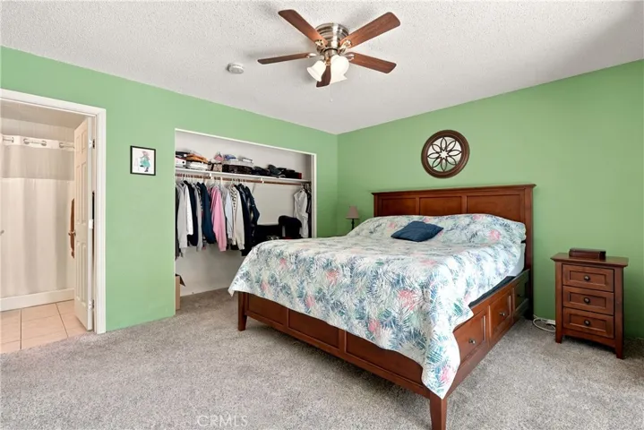 Plush carpet a sizable closet and a ceiling fan create an inviting space to unwind.