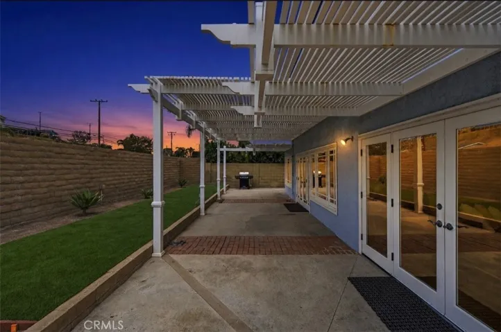 Vinyl patio cover spans the width of the home for added shade and artificial turf adds low-maintenance outdoor space to the backyard.
