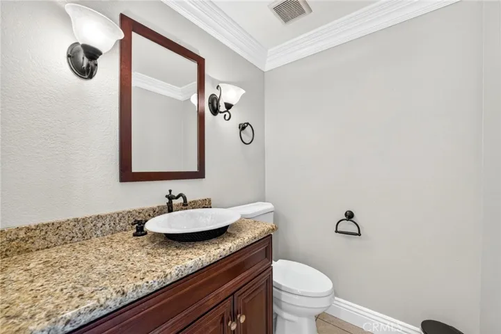 Convenient main-level powder room with granite countertop and updated vanity.