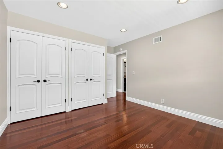 Spacious bedroom features wall-to-wall closets for ample storage.