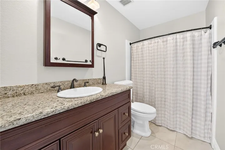 Spacious hallway bathroom with updated vanity and granite countertop.