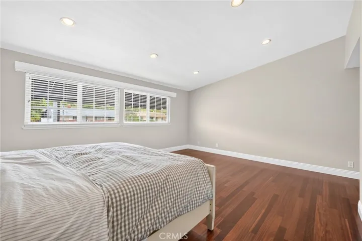 Spacious primary suite with wood flooring and abundant natural light.
