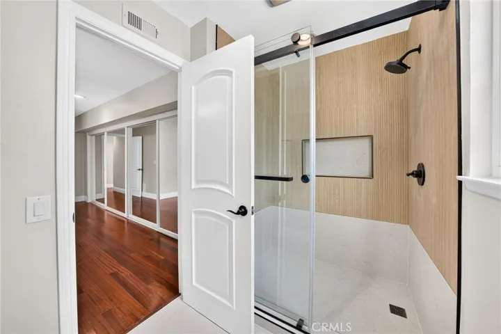 Remodeled primary shower with updated tile and a glass enclosure.
