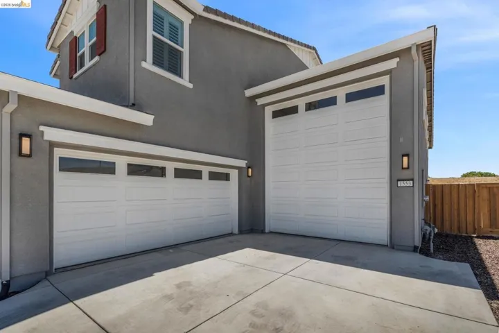 Two white panel garage doors with upper window inserts