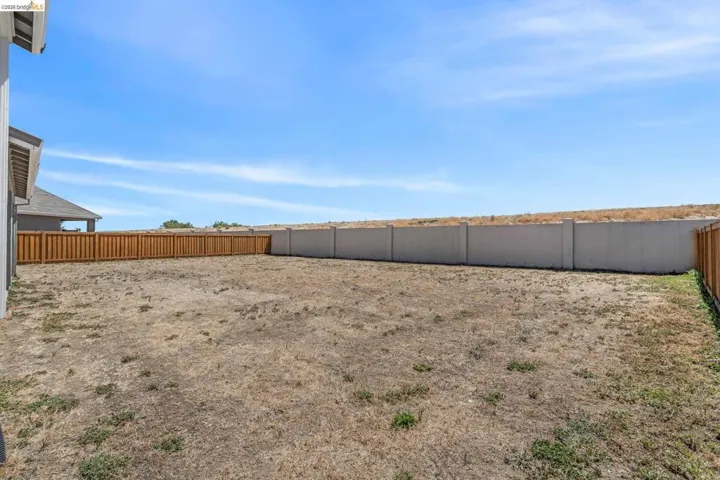 Expansive backyard with a combination of wood privacy fencing and a concrete perimeter wall