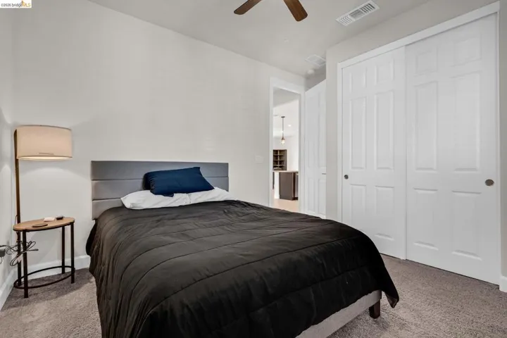 Bedroom featuring carpet flooring, white walls, and a ceiling fan