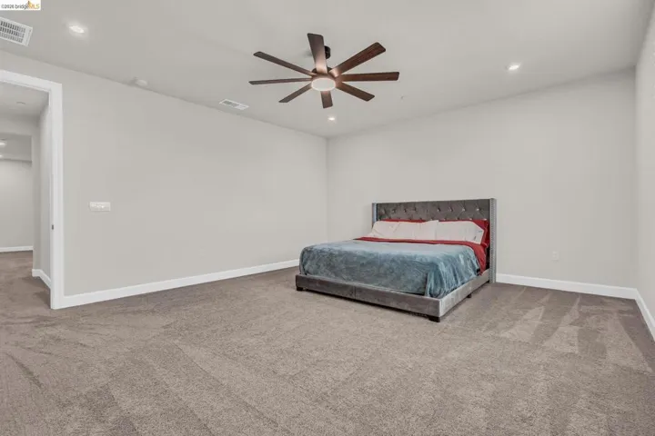 Spacious room featuring neutral carpeting, recessed ceiling lighting, a contemporary ceiling fan, light-toned walls, and white baseboards
