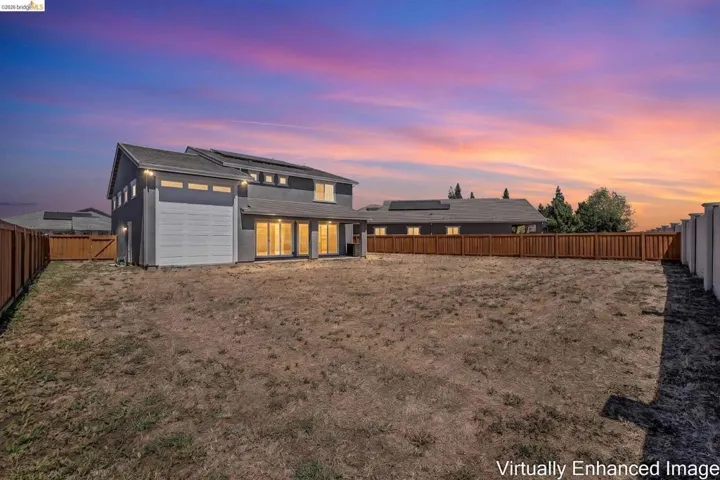 Contemporary two-story residence featuring a stucco exterior, multiple solar panels on the roofline, and a spacious backyard