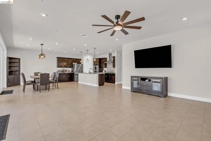 Expansive open-concept living area featuring tile flooring, recessed lighting, and a contemporary ceiling fan
