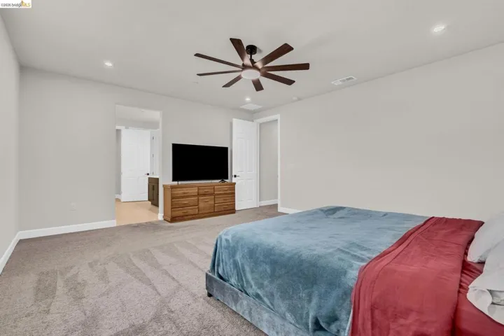 Spacious room featuring neutral carpeting, recessed lighting, and a contemporary ceiling fan
