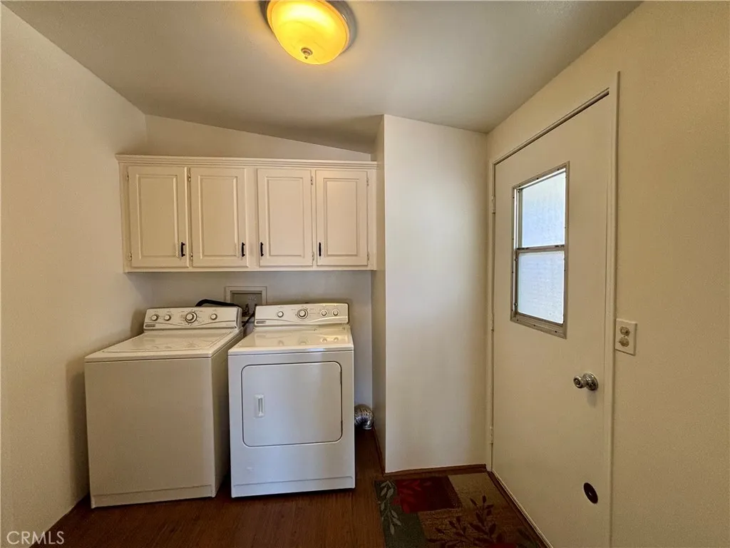 Separate laundry room with newer cabinets