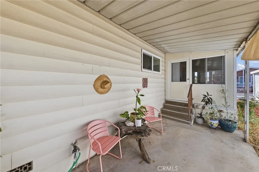 An inviting, cozy patio—perfect for intimate evenings—with a convenient water spigot for potted plants and direct access to the home through the enclosed patio.