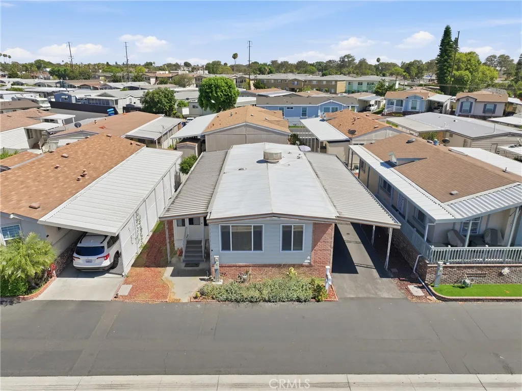 Aerial drone view showcasing the home, its lot, and the surrounding neighbors.