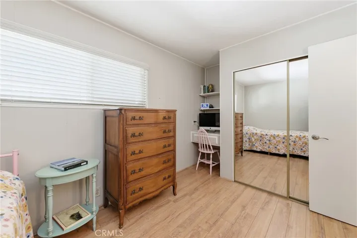 The guest bedroom features mirrored closet doors and a convenient built-in office area.