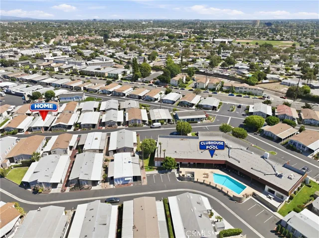 Aerial drone view highlighting the home’s convenient location just steps from the clubhouse and community pool.