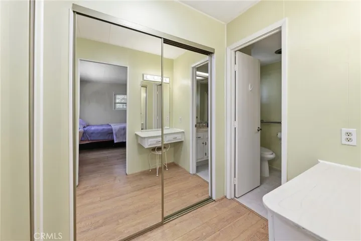 The primary bathroom features a spacious vanity and two mirrored closet doors, providing ample storage.