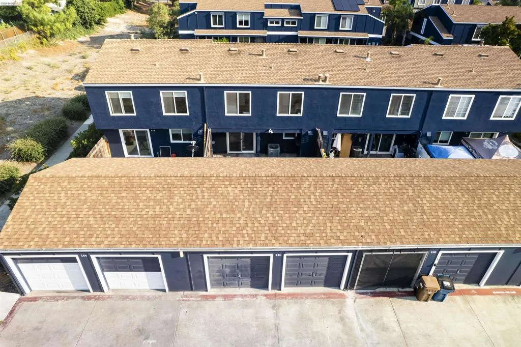 Row of townhomes featuring blue siding and brown shingle roofs