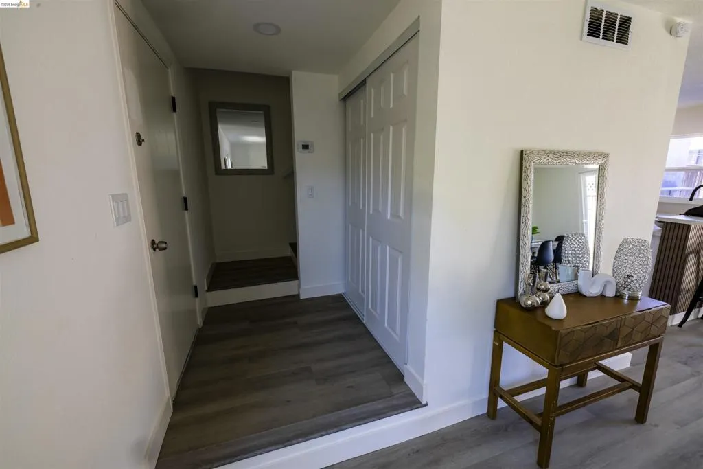 Hallway featuring wood-finish flooring, white paneled doors, and recessed lighting