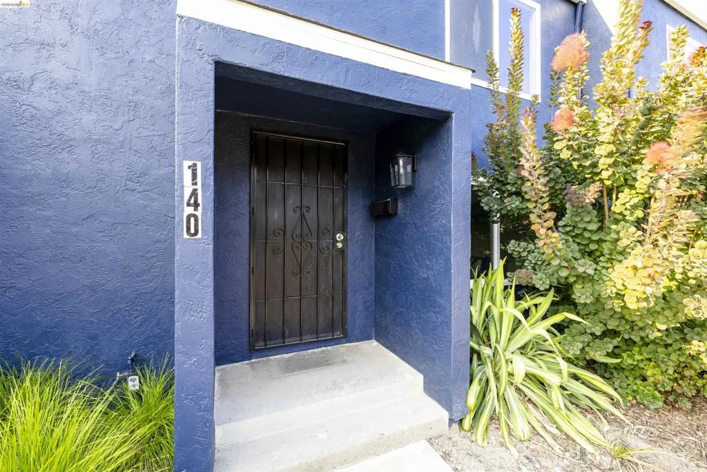 Entryway featuring a security gate, wall-mounted light fixture, and mailbox
