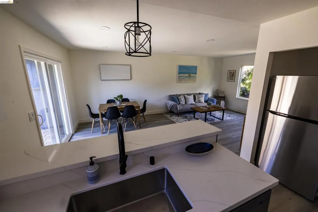 Kitchen peninsula with light-toned countertop and undermount sink