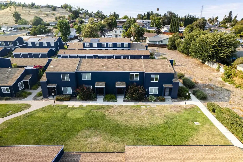 Townhome-style residences featuring dark blue exteriors, light brown shingle roofs, and white window frames