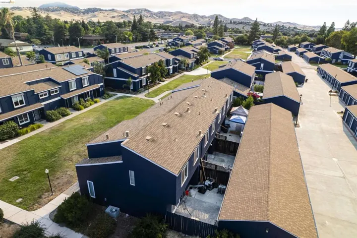 Residential community featuring uniform dark blue exteriors and brown shingle roofs