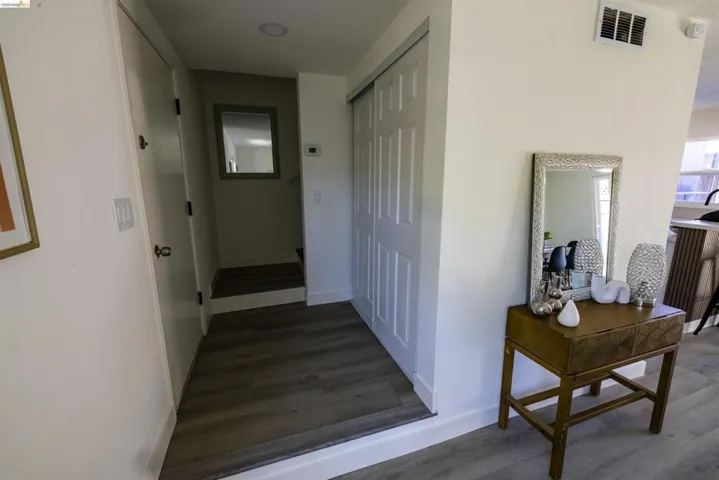 Hallway featuring wood-finish flooring, white paneled doors, and recessed lighting