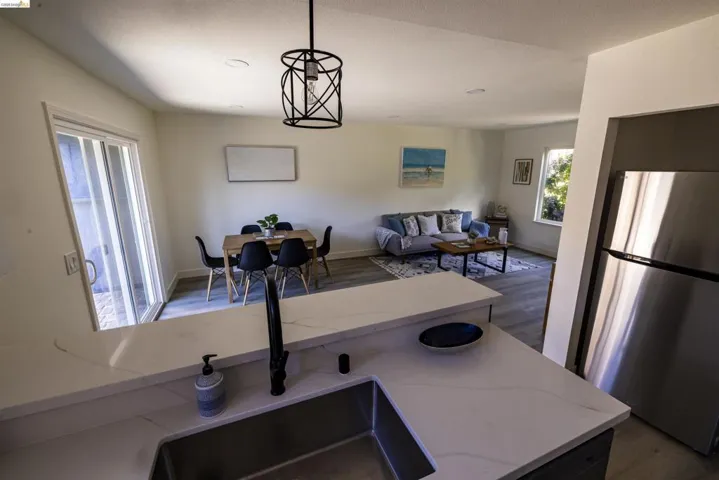 Kitchen peninsula with light-toned countertop and undermount sink