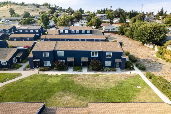 Townhome-style residences featuring dark blue exteriors, light brown shingle roofs, and white window frames