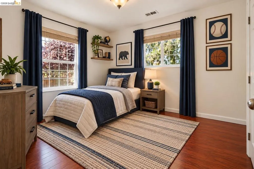 Hardwood-style flooring with a light-toned area rug, windows with wood blinds, and wall-mounted shelving