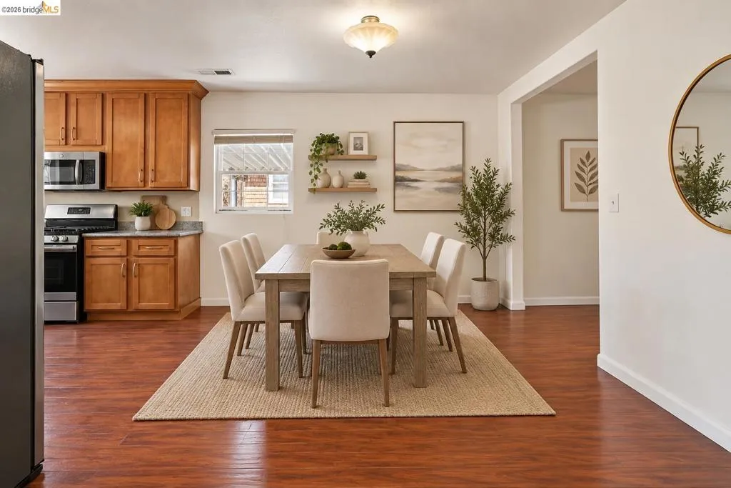 Wood-finish flooring throughout, with a dining area featuring a rectangular table and upholstered chairs