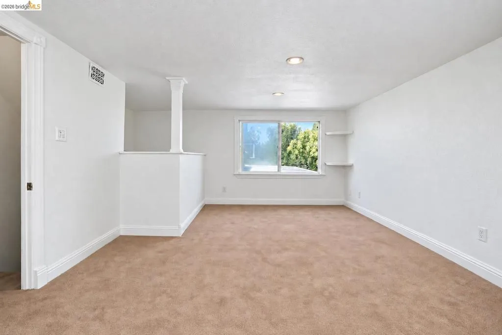 Neutral-toned carpeting, recessed ceiling lighting, and built-in shelving