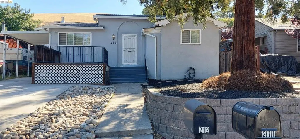Stucco exterior with a covered porch and front deck featuring white lattice