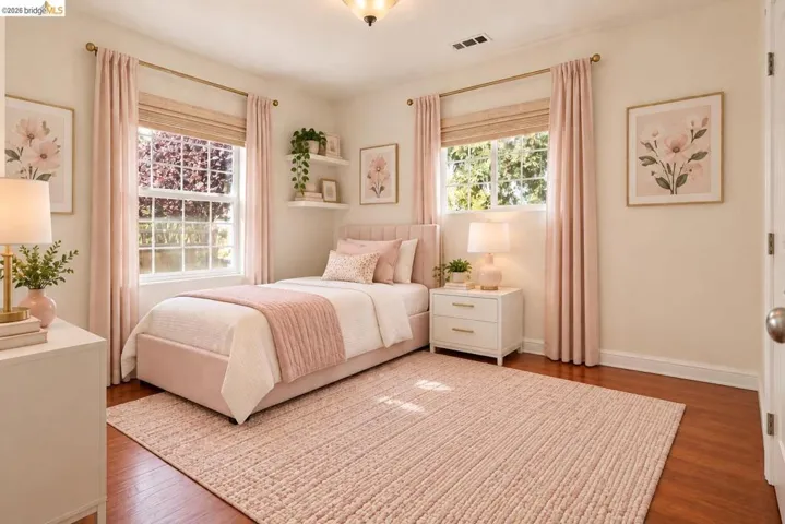 Hardwood flooring, painted walls, two large windows, white trim, and a ceiling-mounted light fixture