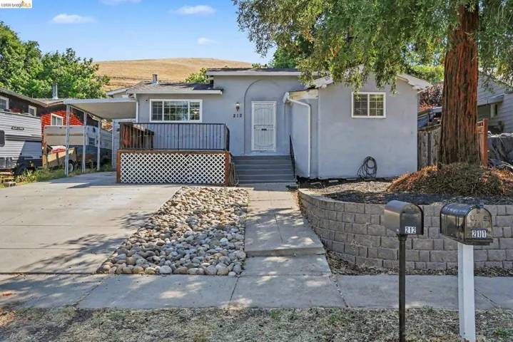 Stucco exterior home featuring an elevated front porch with lattice detailing