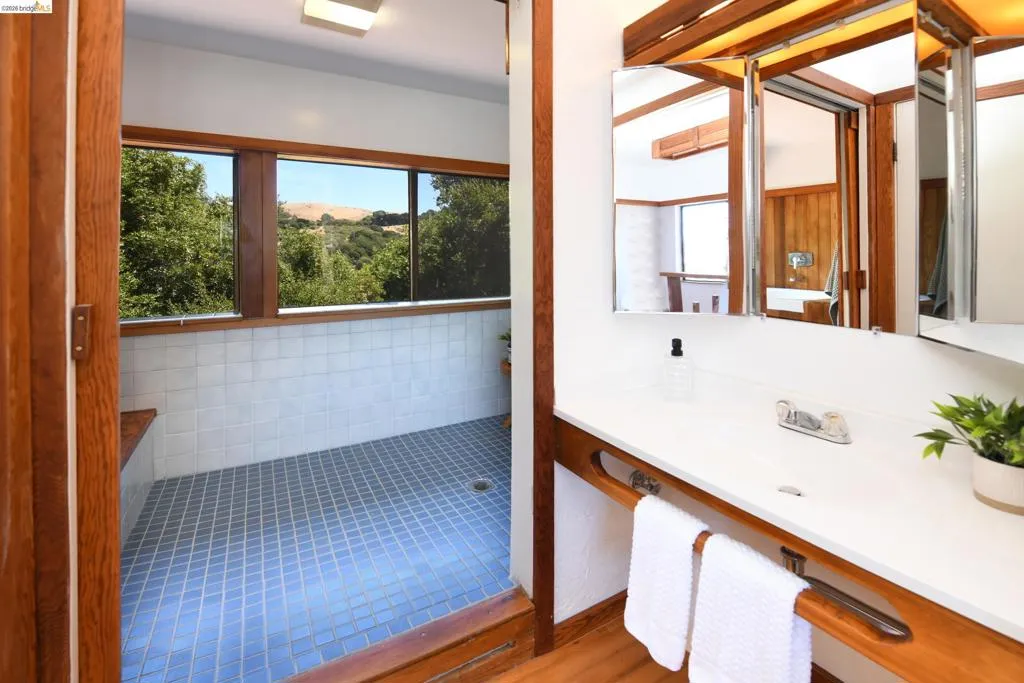 Bathroom featuring a built-in vanity with a white countertop, an integrated sink, and an embedded towel bar