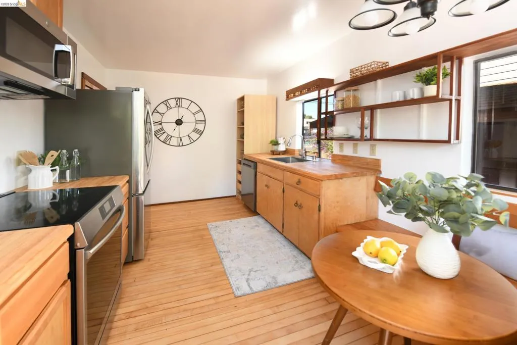 Kitchen featuring wood-finish flooring, light wood cabinetry, and wood countertops