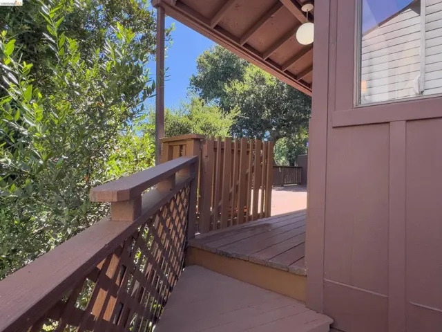Expansive outdoor deck featuring wood-finish flooring, lattice railing, and a matching wood fence