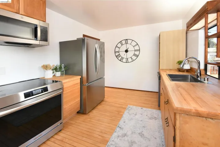 Kitchen featuring wood-finish flooring, natural wood cabinetry, and wood countertops